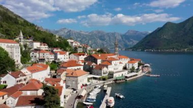 Karadağ 'ın ünlü Kotor Koyu' ndaki tarihi Perast kasabasının mavi gökyüzü ve yaz aylarında bulutlarla dolu güneşli güzel bir günü. Karadağ 'ın Kotor Körfezi' ndeki tarihi Perast kenti yazın.