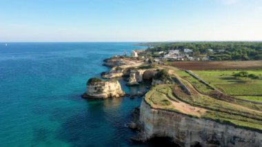 İtalya 'nın Puglia bölgesinde Torre Sant Andrea, Salento sahilinde kayalık kayalık ve yığınlar (Faraglioni) ile büyüleyici deniz manzarası. Sant 'Andrea, Salento, Apulia, İtalya' nın güzel kayalıkları ve deniz yığınları