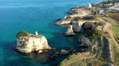 İtalya 'nın Puglia bölgesinde Torre Sant Andrea, Salento sahilinde kayalık kayalık ve yığınlar (Faraglioni) ile büyüleyici deniz manzarası. Sant 'Andrea, Salento, Apulia, İtalya' nın güzel kayalıkları ve deniz yığınları