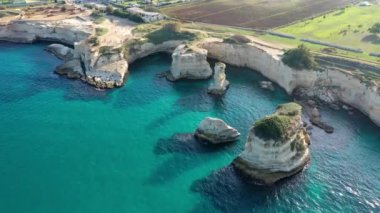 İtalya 'nın Puglia bölgesinde Torre Sant Andrea, Salento sahilinde kayalık kayalık ve yığınlar (Faraglioni) ile büyüleyici deniz manzarası. Sant 'Andrea, Salento, Apulia, İtalya' nın güzel kayalıkları ve deniz yığınları