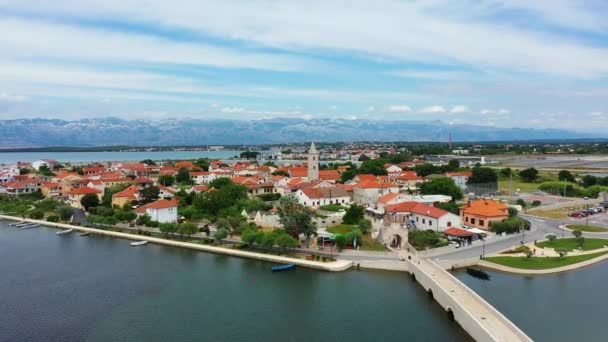 クロアチアのダルマチア地方のVelebit山の背景を持つ歴史的な町ニン ラグナ航空ビュー クロアチアの有名なニンラグーンと中世の空中ビュー — ストック動画
