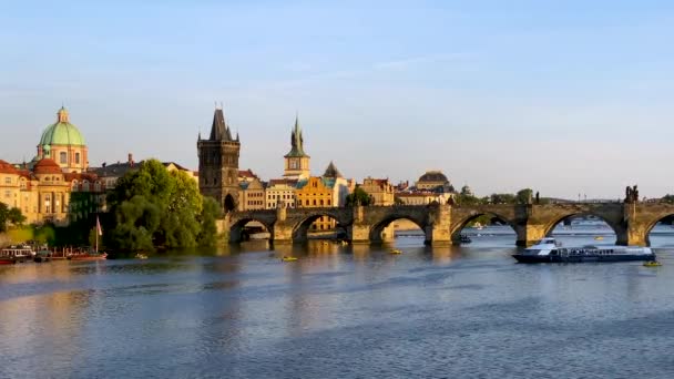 チェコ共和国プラハのヴルタヴァ川にかかる旧市街の桟橋建築とカレル橋の風景 プラハの象徴的なカレル橋 カルロヴィ ヴァリ と旧市街橋塔は チェコの日没時に建てられました — ストック動画
