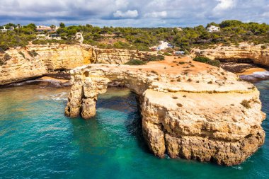 Okyanusun üzerindeki doğal kemer, Arco de Albandeira, Algarve, Portekiz. Praia de Albandeira 'daki taş kemer, Lagoa, Algarve, Portekiz. Portekiz 'in Algarve kentindeki doğal kemer Arco da Albandeira manzarası.