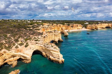 Praia da Marinha, Portekiz, Algarve 'deki güzel sahil Marinha. Deniz Sahili (Praia da Marinha), Algarve 'deki Lagoa Belediyesinin Atlantik kıyısında yer alan plajda uçan martılara sahiptir..