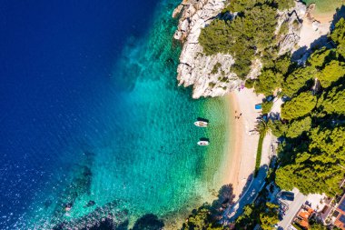 Hırvatistan 'ın Makarska Riviera kentinin Brela kentindeki güzel Podrace plajının muhteşem hava manzarası. Hırvatistan 'ın Makarska Riviera, Brela ve Dalmaçya bölgesindeki Podrace plajı ve liman manzarası.