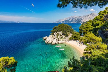 Hırvatistan 'ın Makarska Riviera kentinin Brela kentindeki güzel Podrace plajının muhteşem hava manzarası. Hırvatistan 'ın Makarska Riviera, Brela ve Dalmaçya bölgesindeki Podrace plajı ve liman manzarası.