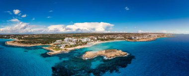 Kıbrıs Rum Kesimi 'nin Ayia Napa kentindeki güzel Nissi plajının hava manzarası. Kıbrıs 'ın Ayia Napa kentindeki Nissi plajı. Kıbrıs Rum Kesimi 'nin Aiya Napa kentindeki gök mavisi bir su manzarası ve Nissi plajı.