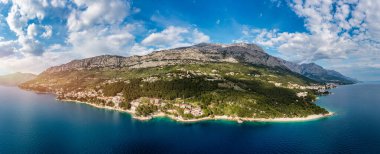 Hırvatistan 'ın Makarska Riviera kentinin Brela kentindeki Punta Rata plajının güzel hava manzarası. Hırvatistan 'ın Makarska Riviera, Brela, Dalmaçya bölgesindeki Punta Rata plajı ve liman manzarası.