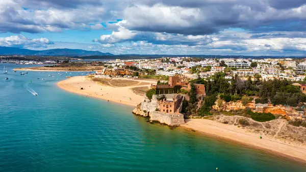 Praia Grande (ana plaj) ve Rio Arade nehri ile Ferragudo, Algarve, Portekiz. Plajı, mağarası ve okyanusu olan güzel bir deniz manzarası Praia Grande Sahili, Ferragudo, Lagoa, Algarve, Portekiz.