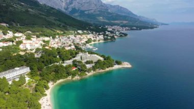 Hırvatistan, Makarska Riviera 'da güzel Brela. Adriyatik Denizi, turkuaz, temiz su ve beyaz kumla. Hırvatistan 'ın Makarska Riviera, Dalmaçya bölgesindeki Brela sahili ve liman manzarası.