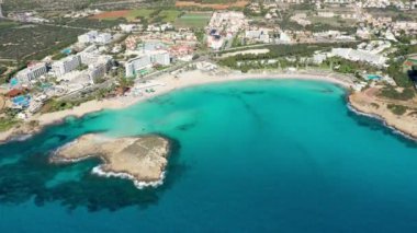 Kıbrıs Rum Kesimi 'nin Ayia Napa kentindeki güzel Nissi plajının hava manzarası. Kıbrıs 'ın Ayia Napa kentindeki Nissi plajı. Kıbrıs Rum Kesimi 'nin Aiya Napa kentindeki gök mavisi bir su manzarası ve Nissi plajı.
