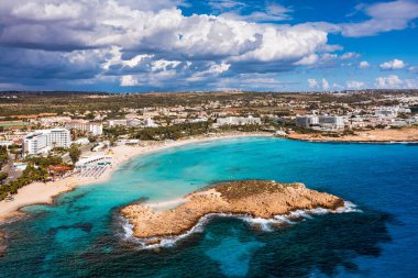 Kıbrıs Rum Kesimi 'nin Ayia Napa kentindeki güzel Nissi plajının hava manzarası. Kıbrıs 'ın Ayia Napa kentindeki Nissi plajı. Kıbrıs Rum Kesimi 'nin Aiya Napa kentindeki gök mavisi bir su manzarası ve Nissi plajı.