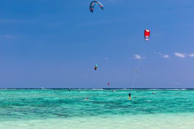 Kite surfers in the waters of Indian Ocean, Mauritius. Kite surfing in the clear waters of the Indian Ocean in Le Morne beach, Mauritius. Best Kite surfing experience at Mauritius island. clipart