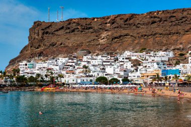 Puerto de Mogan with the beach in Gran Canaria, Spain. Favorite vacation place for tourists and locals on island. Harbor in Puerto de Mogan and Playa Mogan on Grand Canary Island, Spain. clipart