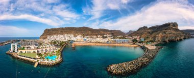 Puerto de Mogan with the beach in Gran Canaria, Spain. Favorite vacation place for tourists and locals on island. Harbor in Puerto de Mogan and Playa Mogan on Grand Canary Island, Spain. clipart