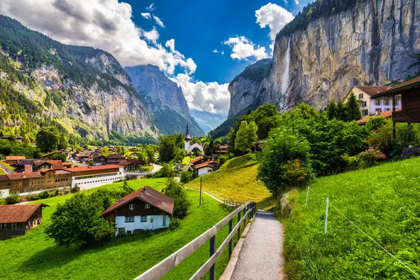 stock image Amazing summer landscape of touristic alpine village Lauterbrunnen with famous church and Staubbach waterfall. Location: Lauterbrunnen village, Berner Oberland, Switzerland, Europe.