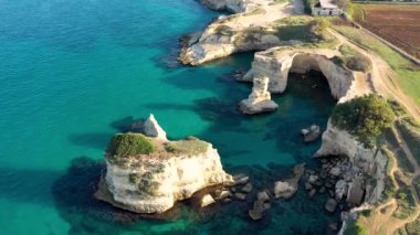 İtalya 'nın Puglia bölgesinde Torre Sant Andrea, Salento sahilinde kayalık kayalık ve yığınlar (Faraglioni) ile büyüleyici deniz manzarası. Sant 'Andrea, Salento, Apulia, İtalya' nın güzel kayalıkları ve deniz yığınları