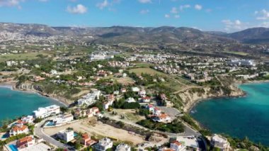 Kıbrıs 'taki Coral Bay plajının havadan panoramik görüntüsü. Kıbrıs Rum Kesimi 'nin Paphos ilçesi Peyia köyü, Coral Bay plajının yukarıdan görünüşü. Kıbrıs Rum Kesimi Peyia köyündeki Coral Bay plajının hava manzarası.