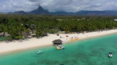 Arka planda Flic en Flac kasabası ve Mauritius dağ manzaralı Flic en Flac plajının havadan manzarası. Mauritius Adası, Flic en Flac 'teki en iyi tropikal plajlar..