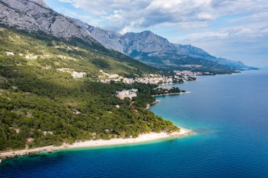 Hırvatistan 'ın Makarska Riviera kentinin Brela kentindeki Punta Rata plajının güzel hava manzarası. Hırvatistan 'ın Makarska Riviera, Brela, Dalmaçya bölgesindeki Punta Rata plajı ve liman manzarası.