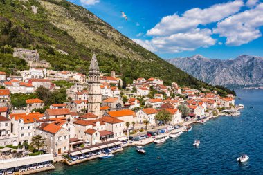 Karadağ 'ın ünlü Kotor Koyu' ndaki tarihi Perast kasabasının mavi gökyüzü ve yaz aylarında bulutlarla dolu güneşli güzel bir günü. Karadağ 'ın Kotor Körfezi' ndeki tarihi Perast kenti yazın.