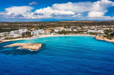 Kıbrıs Rum Kesimi 'nin Ayia Napa kentindeki güzel Nissi plajının hava manzarası. Kıbrıs 'ın Ayia Napa kentindeki Nissi plajı. Kıbrıs Rum Kesimi 'nin Aiya Napa kentindeki gök mavisi bir su manzarası ve Nissi plajı.