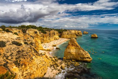 Marinha sahilindeki doğal mağaralar, Algarve Portekiz. Marinha sahilindeki kayalık kemerleri ve Algarve bölgesindeki Portekiz kıyılarındaki turkuaz deniz suyu.. 