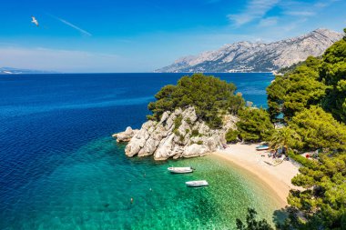 Hırvatistan 'ın Makarska Riviera kentinin Brela kentindeki güzel Podrace plajının muhteşem hava manzarası. Hırvatistan 'ın Makarska Riviera, Brela ve Dalmaçya bölgesindeki Podrace plajı ve liman manzarası.