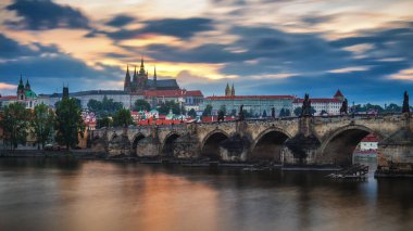 Günbatımında Prag Kalesi ve Charles Köprüsü manzarası. Çek Cumhuriyeti