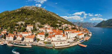 Karadağ 'ın ünlü Kotor Koyu' ndaki tarihi Perast kasabasının mavi gökyüzü ve yaz aylarında bulutlarla dolu güneşli güzel bir günü. Karadağ 'ın Kotor Körfezi' ndeki tarihi Perast kenti yazın.