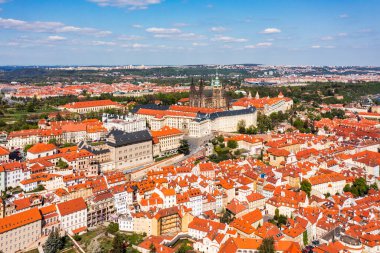 Yazın güneşli bir günde tarihi şato ve canlı çatıların yer aldığı Prag 'ın panoramik manzarası. Prag, Çek Cumhuriyeti 'nin havadan görünüşü şehrin ikonik mimarisini ve kırmızı kiremitli çatılarını gözler önüne seriyor..