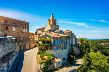 View of Venasque village with old church Notre Dame de Vie to landscape of Luberons, Provence, France. Beautiful Church and houses in the town of Venasque, Provence, France. clipart