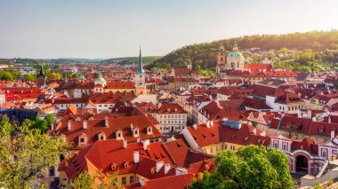 Yazın güneşli bir günde tarihi binaların ve canlı çatıların yer aldığı Prag 'ın panoramik manzarası. Prag, Çek Cumhuriyeti manzarası, şehrin ikonik mimarisini ve kırmızı kiremitli çatılarını gözler önüne seriyor.