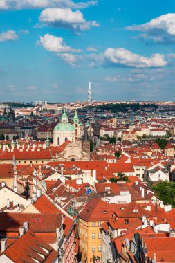 Yazın güneşli bir günde tarihi binaların ve canlı çatıların yer aldığı Prag 'ın panoramik manzarası. Prag, Çek Cumhuriyeti manzarası, şehrin ikonik mimarisini ve kırmızı kiremitli çatılarını gözler önüne seriyor.