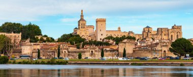 Güney Fransa 'da gün batımında Palais des Papes ile Avignon manzarası. Avignon, Provence, Fransa 'daki Rhone Nehri boyunca ortaçağ mimarisi. Avignon, Güney Fransa 'daki Palais des Papes..