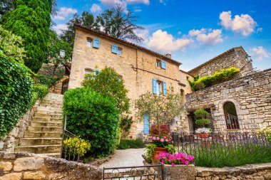 Charming street in quaint Menerbes village with colorful buildings and vibrant flowers. Village of Menerbes (Most Beautiful Village in France) in the Luberon mountains, France, Luberon, Vaucluse. clipart