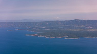 View on mountains and sea from Vidova Gora on Brac island. View from the mountain Vidova Gora on the island Brac in Croatia with the famous landmark Zlatni Rat near the city of Bol an the blue sea. clipart