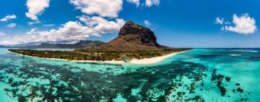 Beach with palm trees and umbrellas on Le morne beach in Mauriutius. Luxury tropical beach and Le Morne mountain in Mauritius. Le Morne beach with palm trees, white sand and luxury resorts, Mauritius clipart