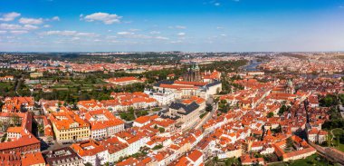 Yazın güneşli bir günde tarihi binaların ve canlı çatıların yer aldığı Prag 'ın panoramik manzarası. Prag, Çek Cumhuriyeti manzarası, Prag ikonik mimarisi ve kırmızı kiremitli çatılar, Çek Cumhuriyeti