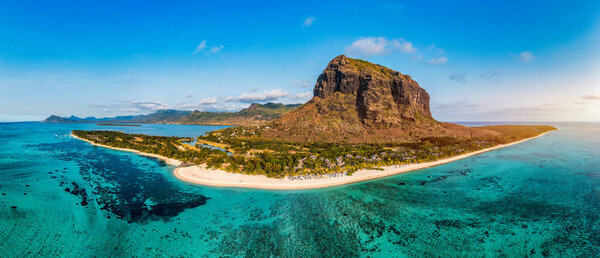 Beach with palm trees and umbrellas on Le morne beach in Mauriutius. Luxury tropical beach and Le Morne mountain in Mauritius. Le Morne beach with palm trees, white sand and luxury resorts, Mauritius