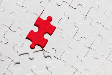 Beyaz yapboz. Renkli arka planda beyaz yapboz parçaları. Renk arkaplanındaki tamamlanmamış beyaz yapboz parçaları. 