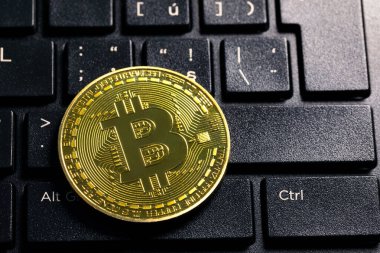 Arka planda bilgisayar klavyesinde Bitcoin elektronik sanal para ve madencilik kripto para kavramının sembolü. Bozuk para şifreli para Bitcoin klavyede yatıyor. Klavyede Bitcoin.