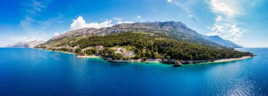 Hırvatistan 'ın Makarska Riviera kentinin Brela kentindeki Punta Rata plajının güzel hava manzarası. Hırvatistan 'ın Makarska Riviera, Brela, Dalmaçya bölgesindeki Punta Rata plajı ve liman manzarası.