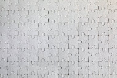 Beyaz yapboz. Renkli arka planda beyaz yapboz parçaları. Renk arkaplanındaki tamamlanmamış beyaz yapboz parçaları. 