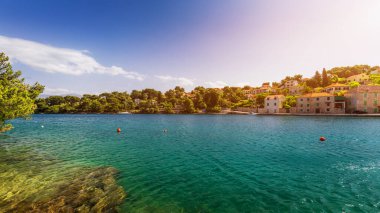 Mavi gökyüzünde güneşli: Splitska köyü Brac Adası, Hırvatistan karşı kilise bina ve palmiye ağacı. 