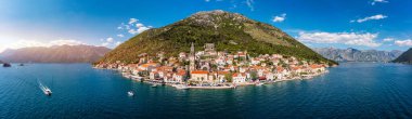 Karadağ 'ın ünlü Kotor Koyu' ndaki tarihi Perast kasabasının mavi gökyüzü ve yaz aylarında bulutlarla dolu güneşli güzel bir günü. Karadağ 'ın Kotor Körfezi' ndeki tarihi Perast kenti yazın.