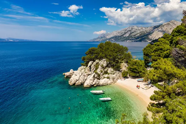 Hırvatistan 'ın Makarska Riviera kentinin Brela kentindeki güzel Podrace plajının muhteşem hava manzarası. Hırvatistan 'ın Makarska Riviera, Brela ve Dalmaçya bölgesindeki Podrace plajı ve liman manzarası.