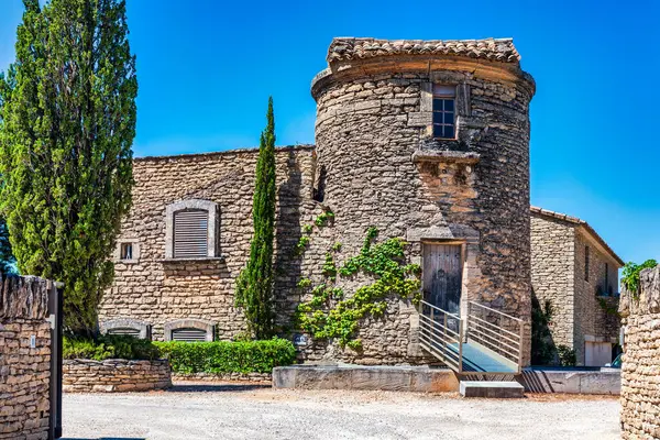 Fransa 'nın Provence kentindeki sakin kırsal alanda yemyeşil yemyeşil bir kulesi olan büyüleyici taş şehir Gordes.