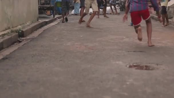 インドのコルカタのガリ道路でサッカーやサッカーをしている子供たち — ストック動画