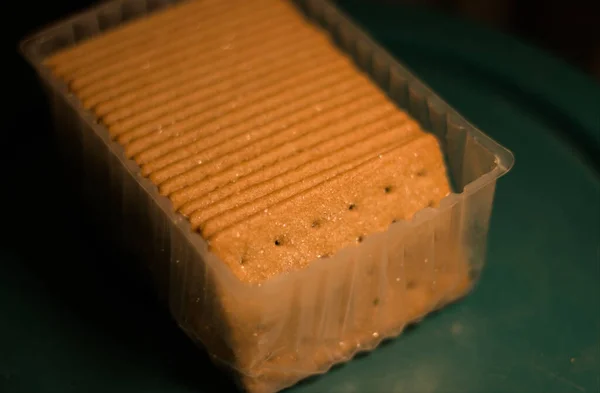 Plastik tepside şeker kaplı bisküviler. Karanlık arka plan. Doğal ışık.